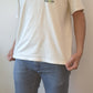 Ein T-Shirt getragen von einem Man mit Logo des Unternehmens Pick it Up auf der Brust