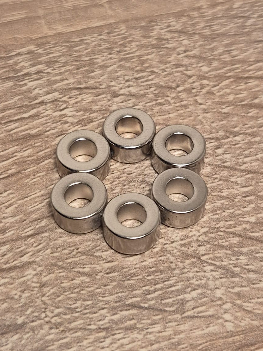 sechs Runde 700g Magnete in einer Kreisform angeordnet liegend auf Holz untergrund